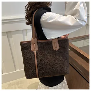 Gros plan du sac cabas en peluche marron montrant la texture laineuse et les anses en similicuir