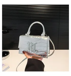 Detailansicht der silbernen Krokodilleder Tasche mit metallischer B-Schnalle und Griff