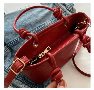 Dettaglio della borsa a secchiello rossa in pelle martellata con zip in metallo dorato