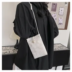 Détail du mini sac bandoulière blanc texturé avec boucle perle et bandoulière fine