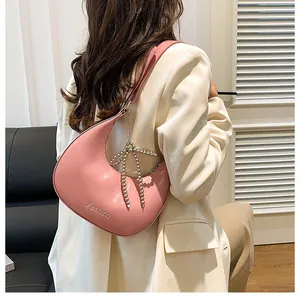 Detailed shot of a pink glossy leather handbag with bead bow and Fashion engraving