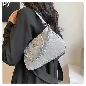 Detail of silver marble underarm bag featuring a metallic butterfly buckle and chain strap