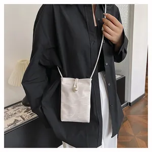 Détail d'un mini sac bandoulière ivoire avec texture marbre et fermoir en perle
