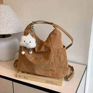 Sac à bandoulière kaki avec papillon métallique et charme nuage en peluche