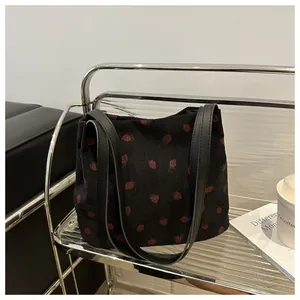 Détail de l'imprimé fraise sur cabas en velours noir avec poignées en cuir noir