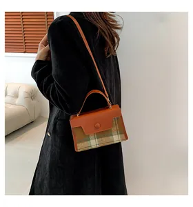 Sac bandoulière en cuir marron et patchwork à carreaux dans un décor minimaliste