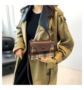 Détail d'un sac bandoulière à carreaux marron avec boucle décorative ronde élégante