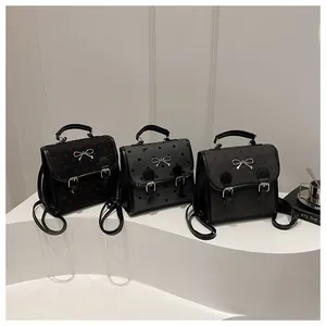Detailed shot of mini backpacks with metal bows and varied patterns on white pedestals
