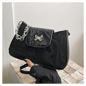 Detail of black marble textured bag with silver butterfly clasp and chunky chain strap