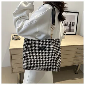Détail du sac cabas en pied-de-poule noir et blanc avec bandoulière et chaîne dorée