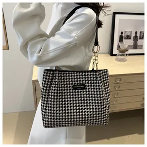 Détail du sac cabas en pied-de-poule noir et blanc avec anses cuir et chaîne dorée