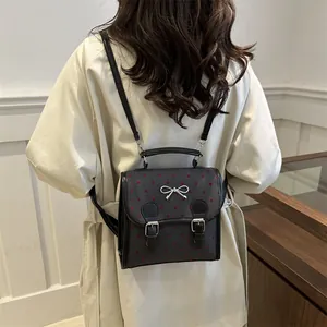 Fashionable black women's backpack with red heart patterns and silver bow buckle detail