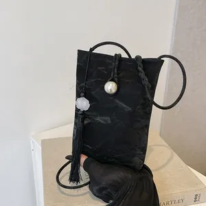 Mini sac à bandoulière noir avec texture plissée, boucle perle et franges longues