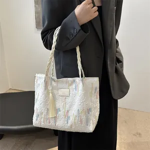 Elegant white fabric tote bag with colorful wave embroidery and tassel decoration