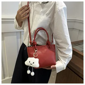 Mini borsa a secchiello rossa in pelle martellata con ciondolo a nuvola e tracolla