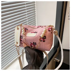 Detail showing pink cylinder pillow bag with cat prints and elegant pearl handle