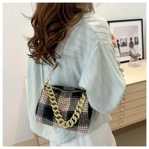 Détail d'un sac à carreaux rétro avec chaîne dorée et texture en tissu de qualité