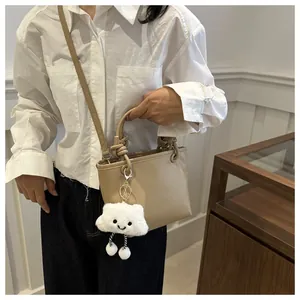 Dettaglio della borsa a secchiello in pelle martellata kaki con manico a nodo e charm a nuvola