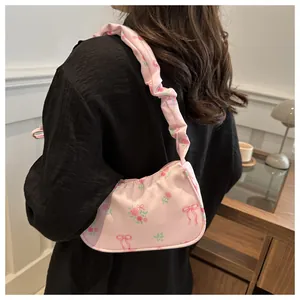 Vue détaillée du sac rose avec motifs de roses et poignées à effet froissé