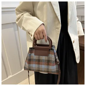 Braune Plaid-Tweed-Umhängetasche getragen von Modell in Kombination mit einem beigen Cord-Blazer