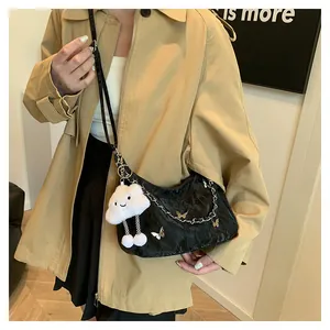 Detail of black pleated shoulder bag with silver butterflies and plush cloud charm
