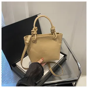 Dettaglio borsa a secchiello in pelle martellata marrone con manico a nodo elegante