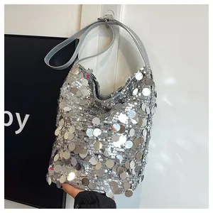 Dettaglio di grandi paillettes argento su una borsa a secchiello con finitura lucida