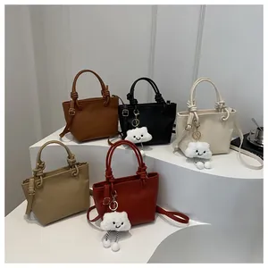 Dettaglio di borse a secchiello alla moda in cinque colori con ciondoli a nuvola