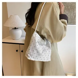 Nahaufnahme der weißen Polka-Dot-Stofftasche mit feiner Textur und schmalem Schultergurt