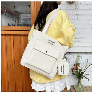 Detail der cremefarbenen Canvas-Tragetasche mit Fronttasche und kleiner Anhängertasche