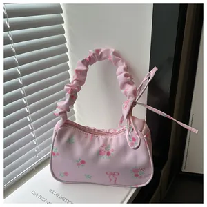 Détail du sac floral rose avec motif de roses et poignée nuage à volants