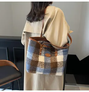 Mannequin portant un grand sac cabas en peluche à carreaux avec des anses en cuir marron