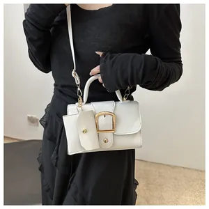 Close-up of white square handbag with golden buckle and mini coin purse detail
