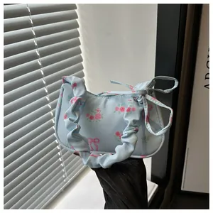 Détail du sac hobo bleu clair avec roses roses et poignée nuage à volants