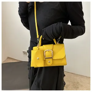 Detail of yellow lychee grain mini handbag with metal buckle and chain strap