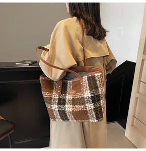Grand sac cabas à carreaux avec bandoulière en cuir marron porté par un mannequin