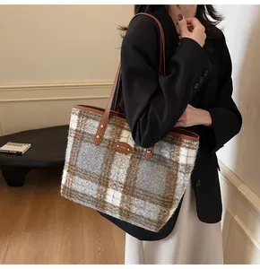 Détail du sac cabas à carreaux en laine marron avec anses en cuir pour le trajet d'hiver