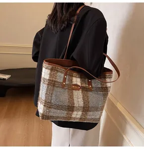 Détail du sac cabas pelucheux à carreaux avec poignées en cuir brun et rivets dorés