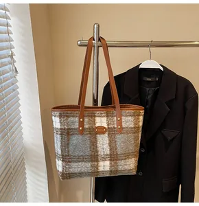 Détail du sac cabas en tweed à carreaux avec anses en cuir marron pour l'hiver