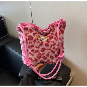 Dettaglio borsa leopardata in ecopelliccia rosa con ricamo e tracolla annodata