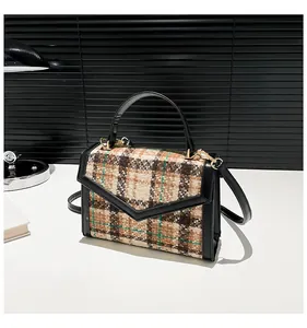 Detail van de geruite tweed schoudertas met lederen flap en gouden fittingen