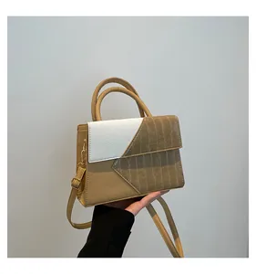 Macro detail of tricolor handbag showing crocodile texture and dual ring handles