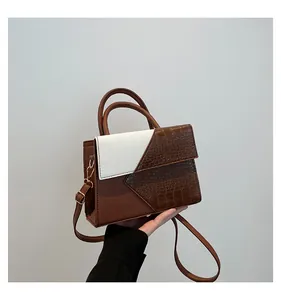 Detail of brown and white crossbody bag featuring lychee grain and crocodile texture