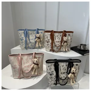 Detail view of four large graffiti tote bags with bear charms in various colors