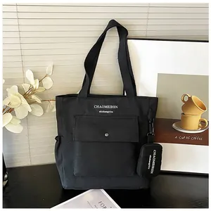 Details einer schwarzen Canvas-Tasche mit Fronttasche und abnehmbarem Portemonnaie