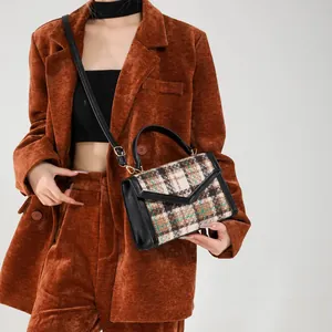 Retro crossbodytas met ruitpatroon en zwart lederen bies op een camel corduroy pak