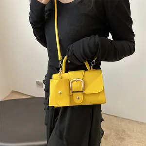 Vibrant yellow square crossbody bag with gold buckle and mini coin purse accessory