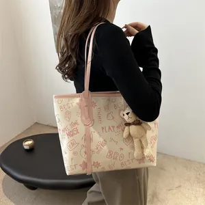 Chic beige tote bag with pink graffiti patterns and a cute knit bear charm