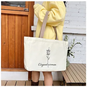 Détail d'un grand sac fourre-tout beige avec motif rose noire et texte élégant