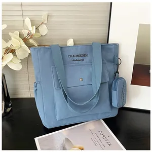 Detailansicht der blauen Canvas-Tasche mit Metalldruckknopf und passendem Münztäschchen